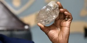 Botswana's President Mokgweetsi Masisi holds a large diamond discovered in Botswana at his office in Gaborone on August 22, 2024. MONIRUL BHUIYAN/Getty Images